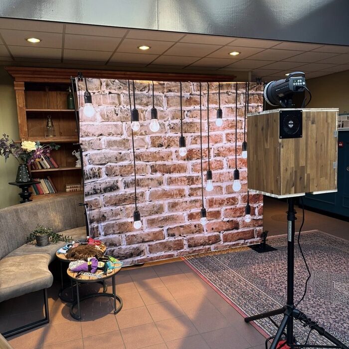 Fotobox vor gemütlichem Backstein-Hintergrund mit Lichterkette