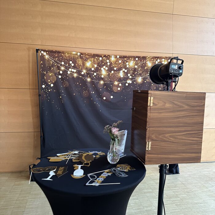 Fotobox-Ecke mit goldschwarzem Glitzer-Hintergrund und Verkleidungs-Requisiten